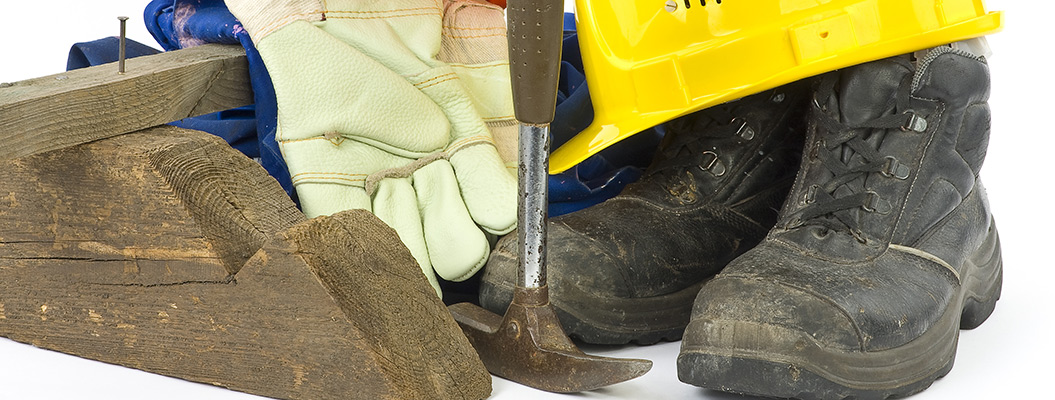 Ein Lattenhammer und die Arbeitsschutzbekleidung eines Bauarbeiters